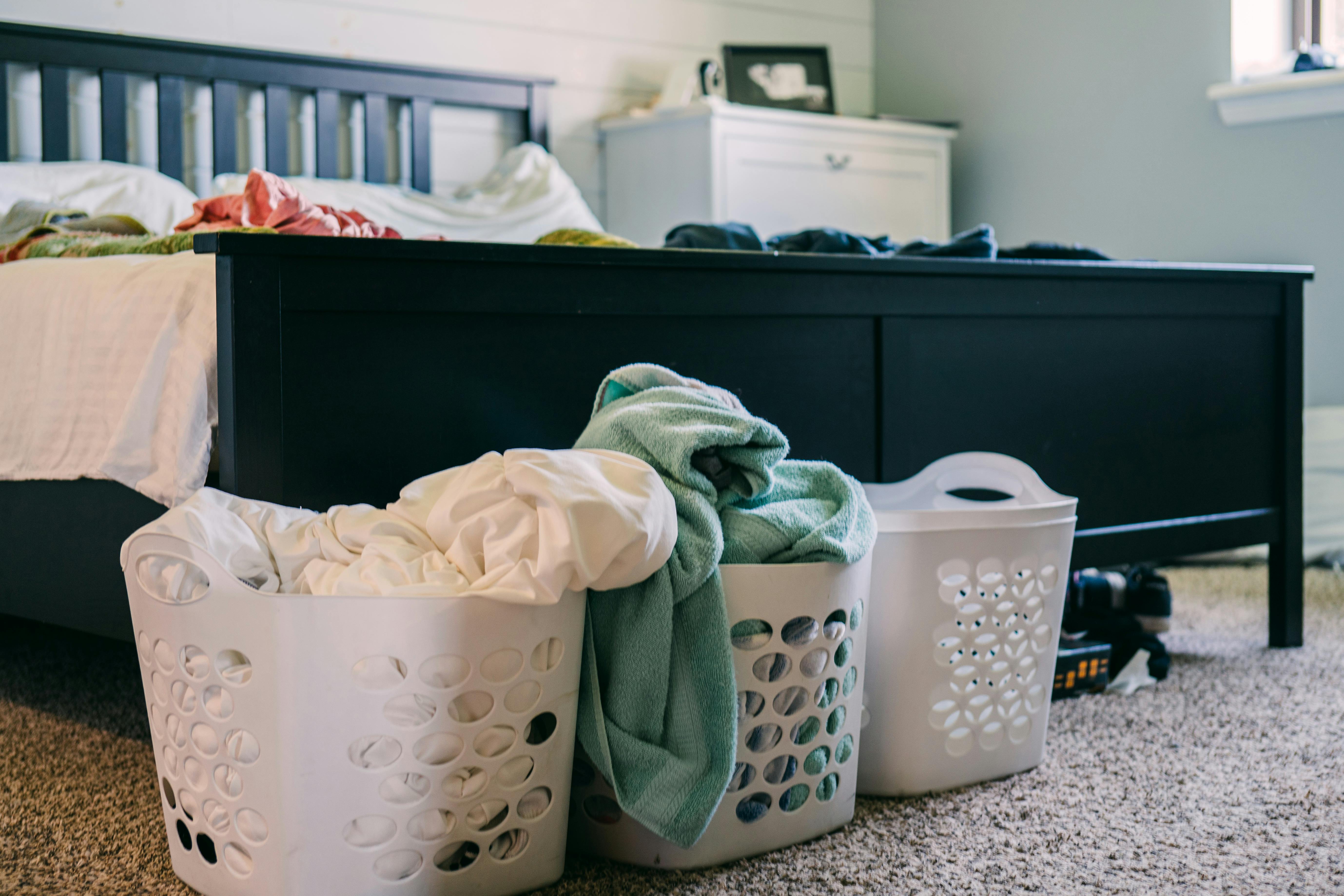 Laundry baskets and fresh linens in a bedroom